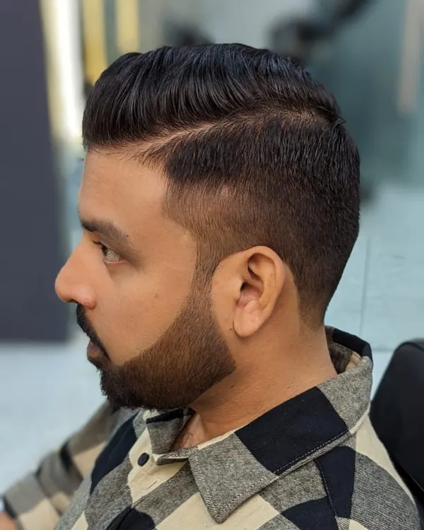 A perfect example of a sharp, modern men's haircut. The skin fade is seamlessly blended, and the beard is lined up with precision for a clean and polished finish.