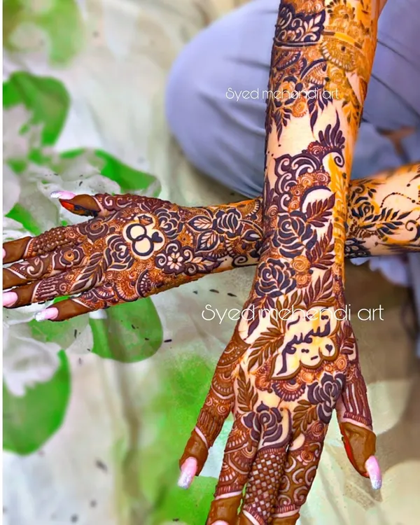 An engagement henna design with personalized rings and names, looking beautiful on the client.