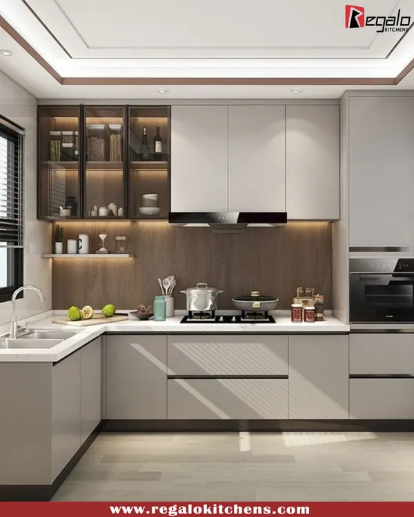 This L-shaped kitchen is a perfect example of modern efficiency. We used a two-tone scheme of grey and wood, with glass-front upper cabinets for display. The layout provides ample counter space and a clear, organized workflow from the sink to the stove.