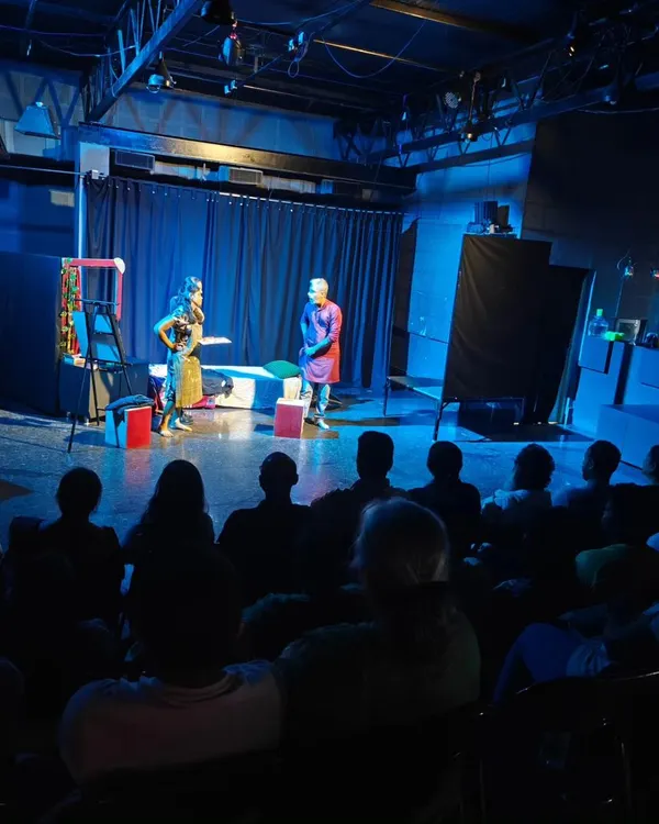 A wide shot showing the full expanse of our stage during a performance. The dramatic blue lighting and packed audience create a truly immersive atmosphere for any play.