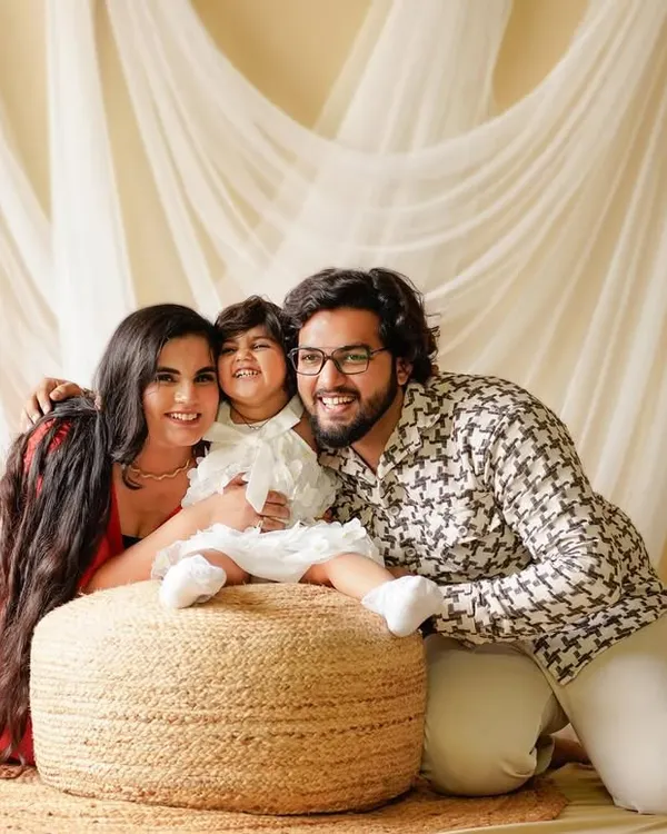 A happy family portrait from our boho studio set. The natural jute pouf, sheer curtains, and simple greenery create a warm and inviting atmosphere for capturing genuine smiles.