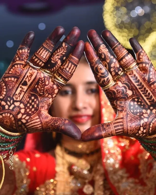 This is what it's all about. A beautiful bride, her complete look, and a deep, rich henna stain that stands out. I love personalizing the design, and here you can see the couple's names, Sani and Zahi, woven right into the pattern on her palms.