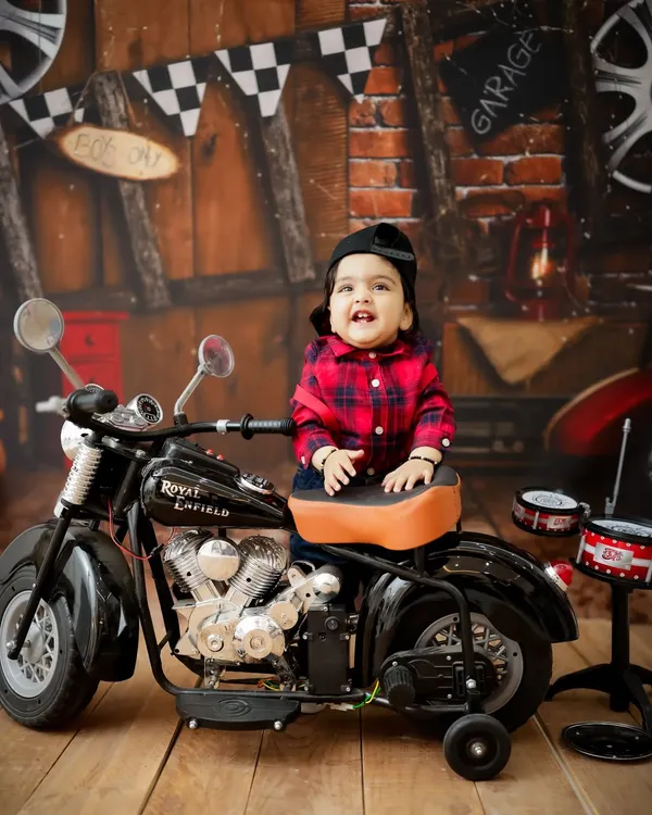 Born to be wild! This little guy is ready to hit the road in our biker-themed setup, featuring a miniature motorcycle and a cool garage backdrop.