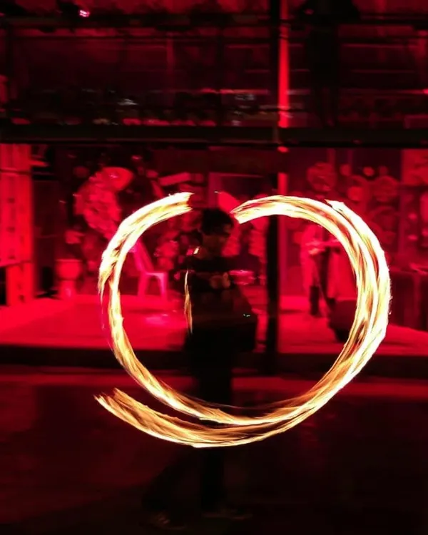 A captivating shot of a fire-spinning performance, with flames forming a heart shape in the dark, industrial-chic setting of our Central Arena. This image perfectly encapsulates the magic and unique experiences we host.