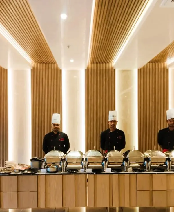 Our professional team stands ready to serve at a dinner party, showcasing a clean, elegant buffet setup in a modern venue. We ensure every detail is handled for a seamless experience.