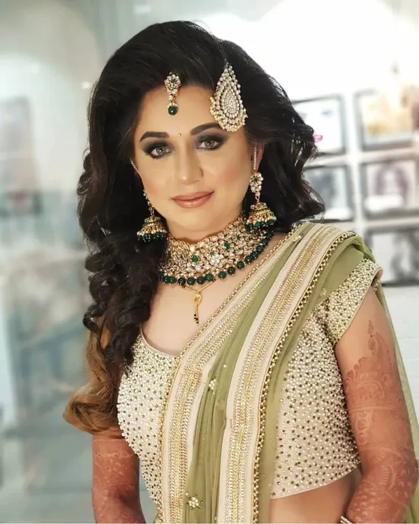 A stunning reception look featuring a bold smokey eye, perfectly contoured cheeks, and a sophisticated nude lip. Paired with soft, open hair, this look is modern, glamorous, and perfect for an evening party.