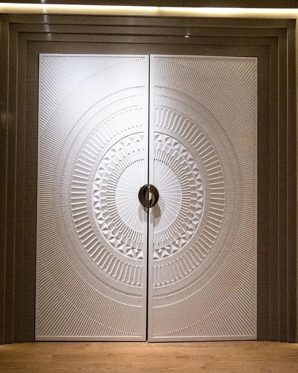 A main door should make a grand statement. This double door features a spectacular 3D-carved circular design, finished in a matte pigmented PU paint that gives it a smooth, stone-like appearance. It's a true centerpiece for any entrance.