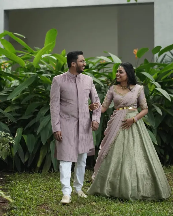 A beautiful moment between Dr. Tushara and her partner. I designed his elegant mauve Indo-Western sherwani to subtly complement the delicate embroidery on her custom half-saree, creating a harmonious look for their event.