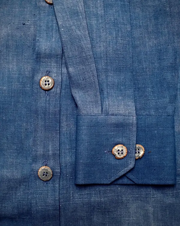 A close-up of the finished custom ceramic buttons on a hand-stitched indigo shirt. It was so rewarding to see how they provided the perfect finishing touch.