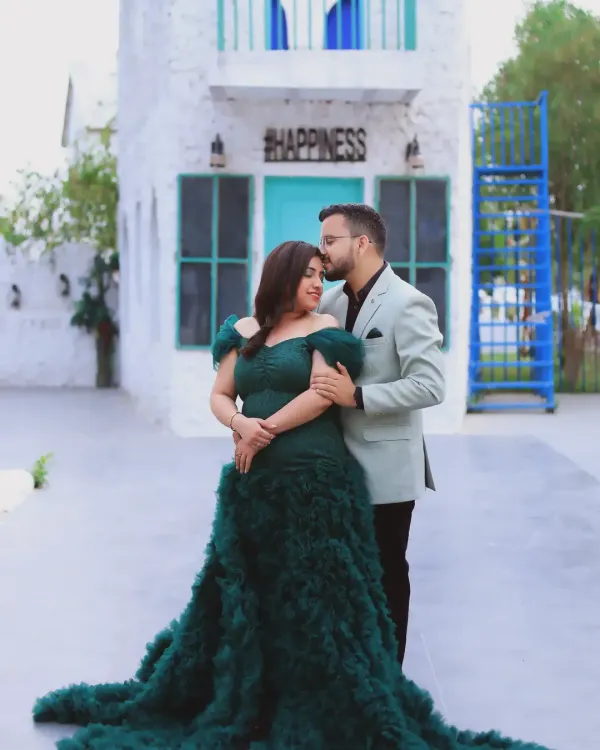 A classic couple's maternity portrait. The combination of the elegant green gown and the simple, happy backdrop makes for a beautiful and romantic photograph celebrating your journey together.