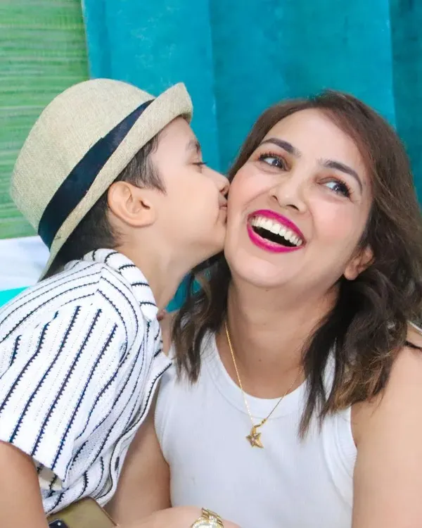 We love capturing those unscripted moments of affection. Here, a son gives his mother a happy kiss on the cheek, a perfect example of the candid family photography we specialize in.