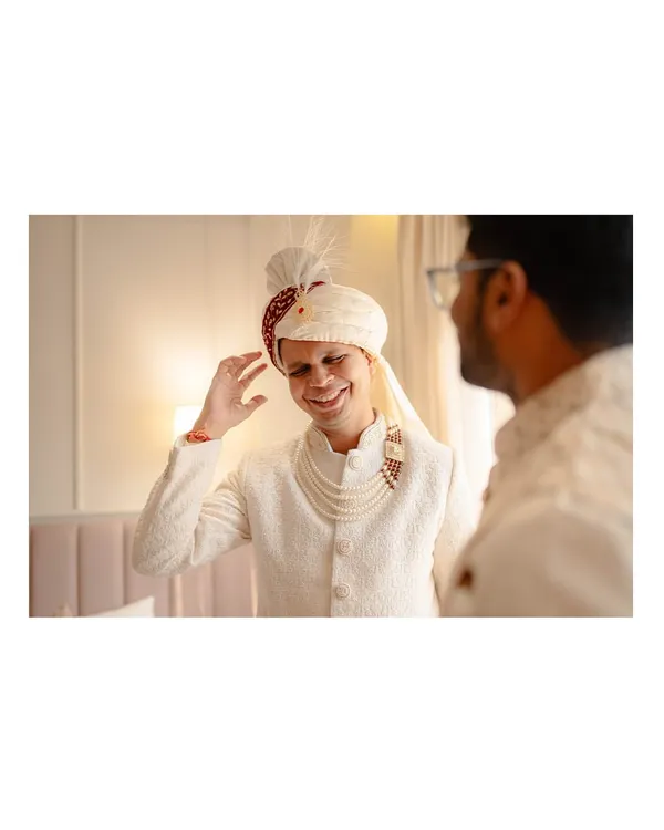 The groom, Abhishek, shares a laugh while getting ready for his Bengali wedding ceremony.