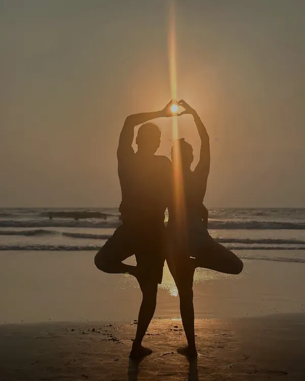 Practicing yoga with a partner is about creating something beautiful together. Here we are in a partner Tree Pose, forming a heart against the sunset to symbolize the strength and courage that comes from loving deeply.