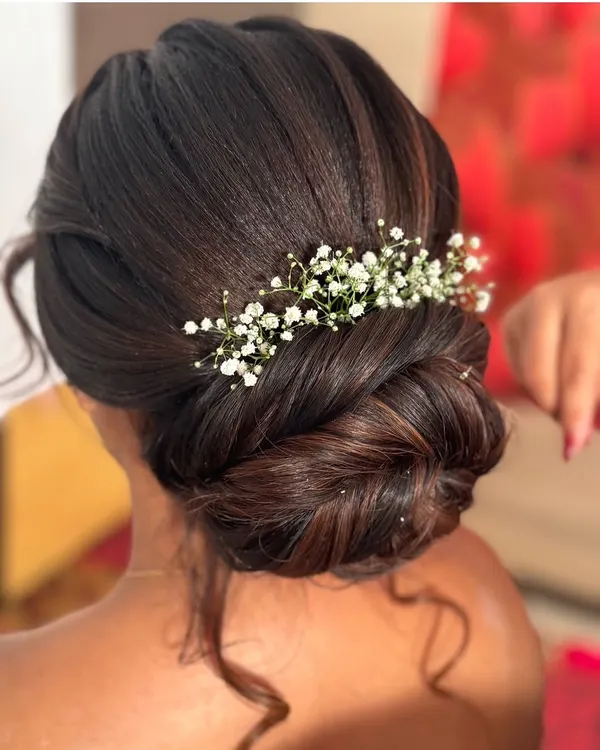 A classic bun is always a royal and elegant choice. This beautifully twisted low bun is adorned with delicate baby's breath, perfect for a reception or engagement.