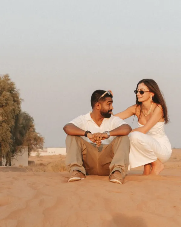 A candid moment of connection in the Dubai desert. The soft light and natural interaction showcase a relaxed and authentic pre-wedding photography style.