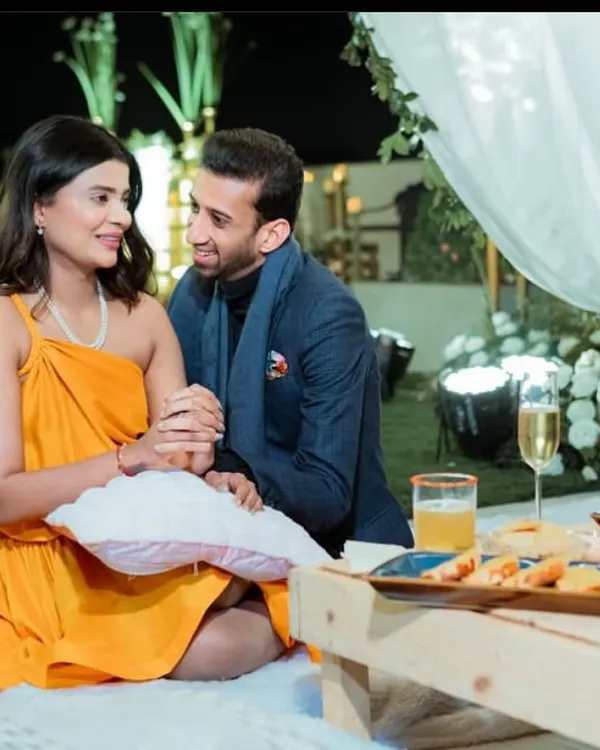 A beautiful, intimate moment from a surprise proposal we helped plan. The couple is seated in a cozy picnic setup, surrounded by the soft glow of candles and fresh flowers.