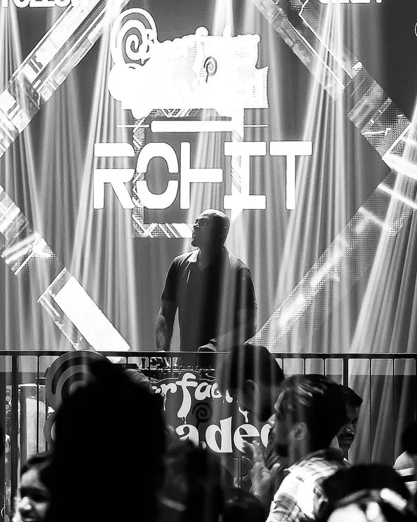 A dramatic black and white shot of me at the console at Sugar Factory, focused on the mix. The lighting and stage setup here are incredible.