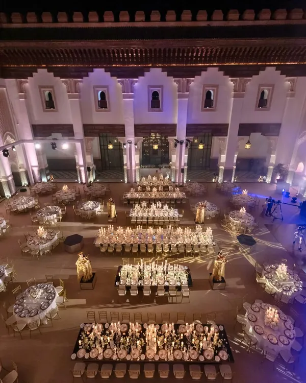 A palatial ivory-and-gold sit-down dinner in a grand courtyard in Marrakech. The layout with long and round tables created a formal yet social atmosphere to toast the newlyweds.