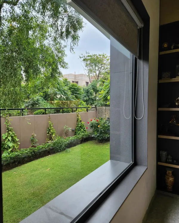 A large window in one of our residential projects perfectly frames the lush green garden outside, bringing the peace of nature indoors. We prioritize creating such connections to achieve a resort-like living experience in the city.