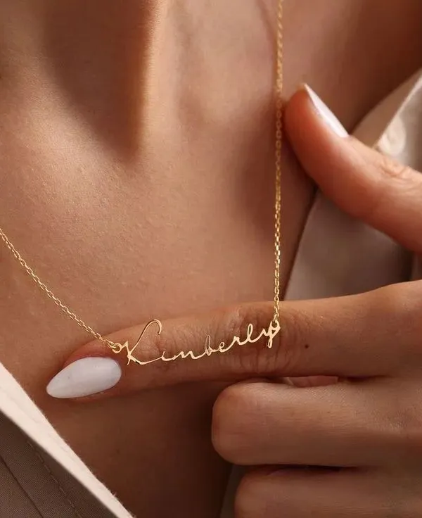 A close-up view of the 'Kimberly' script necklace, showcasing the delicate yet durable chain and the precision of the lettering. This is a timeless piece that rests beautifully on the collarbone.