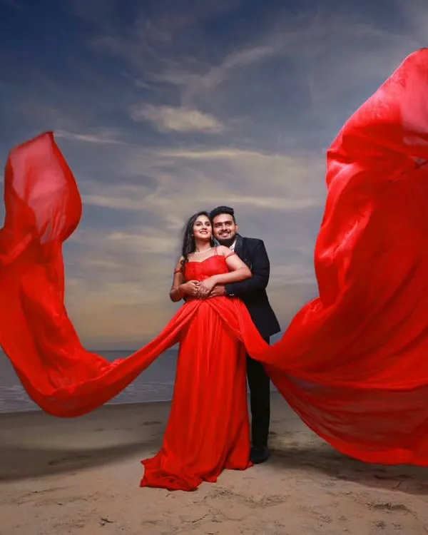 A dramatic pre-wedding photoshoot on the beach. I styled the couple completely, providing this stunning red flying gown and a sharp suit for the groom, along with makeup that stayed flawless by the sea.