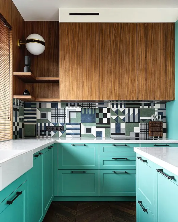 Luxury redefined. This kitchen design showcases a bold use of color and pattern, with teal cabinets, a striking geometric tile backsplash, and rich wood accents. It's a perfect example of a kitchen that reflects personality.