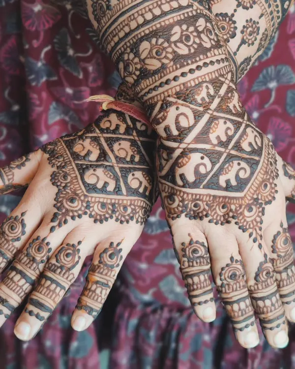 A beautiful design featuring a grid of baby elephants on the back of the hand. It's a traditional pattern with a cute and modern twist.