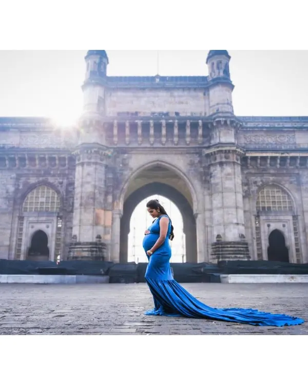 A truly iconic maternity shoot. This royal blue trail gown creates a stunning silhouette against the Gateway of India, making for a powerful and memorable photo.