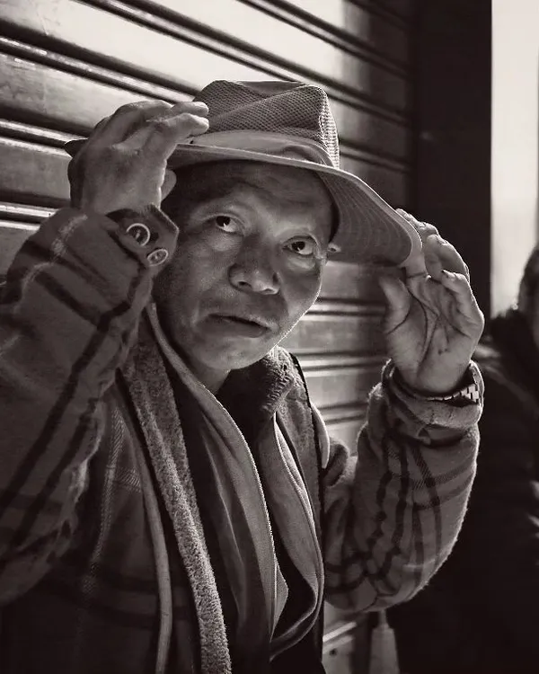 I believe that when you photograph people in black and white, you capture a piece of their soul. This candid portrait, taken in a quiet moment, focuses on the man's expression and character, stripping away the distraction of color to tell a more profound story.