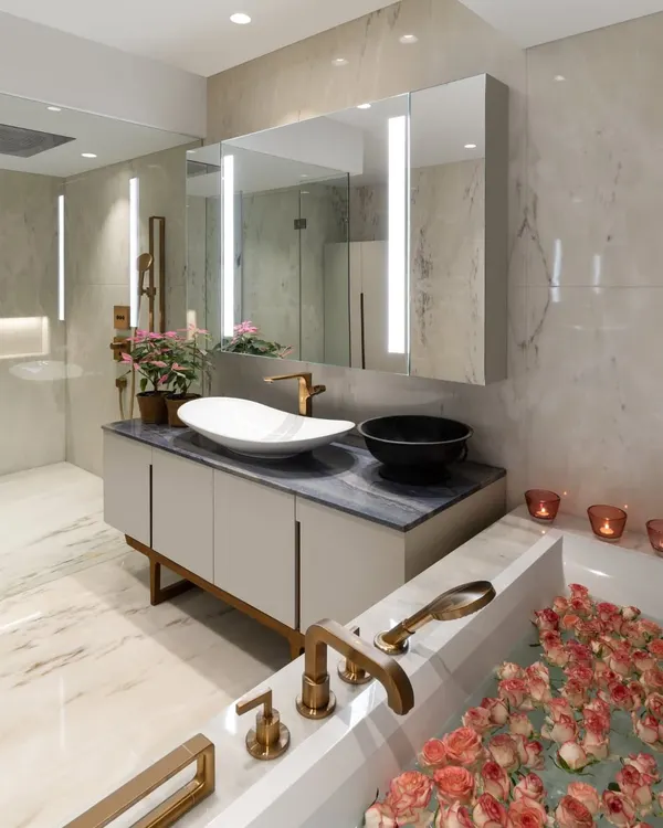A master bathroom designed as a spa-like retreat. The bathtub is filled with rose petals, and the vanity from our Koko collection features elegant lines and high-quality materials. We believe every corner of a home should be treated with intention and care.