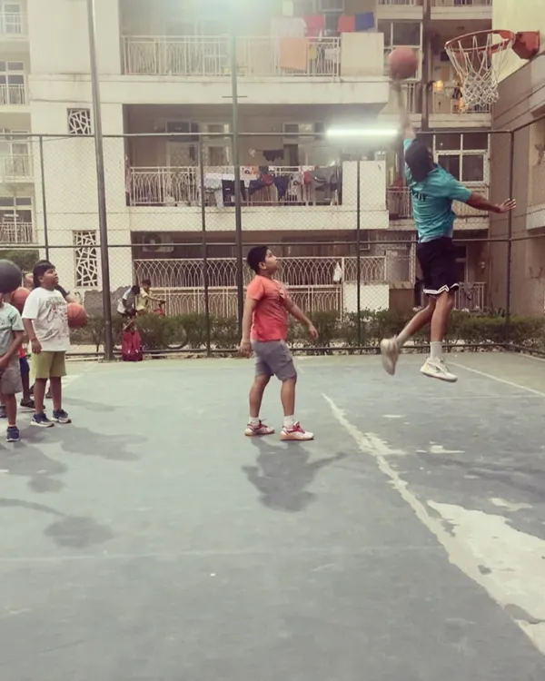 I love showing the kids what's possible. Here I am going up for a dunk while they watch. It inspires them to work hard and aim high.