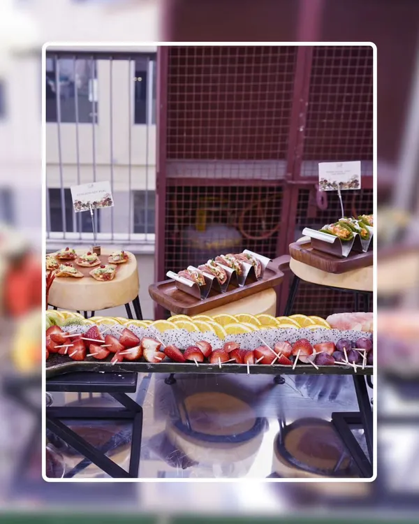 A full view of our appetizer station at an outdoor event. This setup includes fresh fruit skewers, mini tacos, and other bite-sized snacks, all beautifully arranged and ready for guests.
