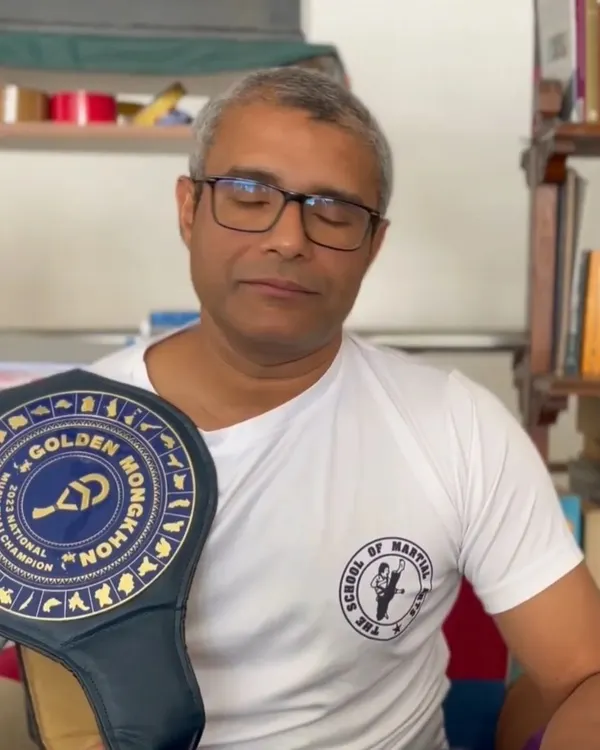 Our founder and chief instructor, Ashwin Naidu, holding a national championship belt from the Golden Mongkhon series. Our leadership's success in the ring is the bedrock of our training credibility.