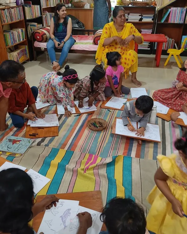 Children are deeply engaged in a coloring activity related to our story about sea animals. Using lapboards on the floor creates a relaxed and comfortable crafting environment.