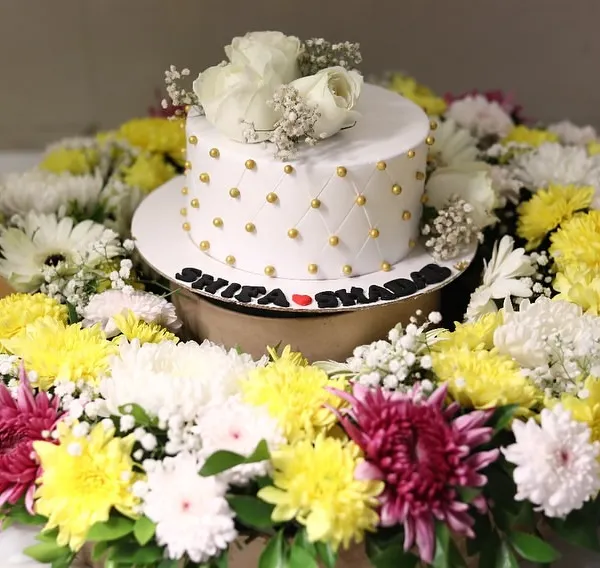 We love combining flowers and treats. This vibrant floral platter was designed to perfectly frame a custom cake, creating a stunning centerpiece for a nikah ceremony or any special event.