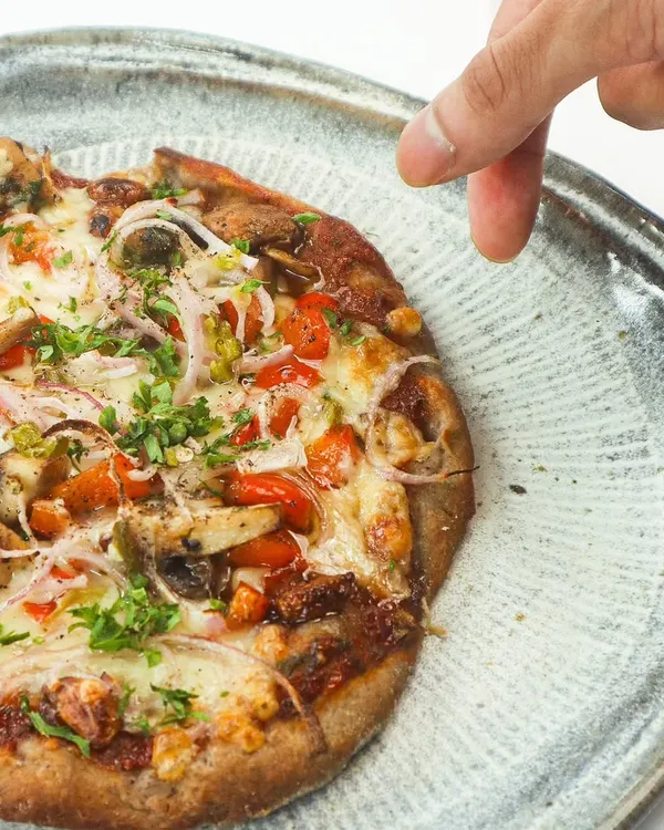 Meet our Confit Garlic and Smoked Mushroom Pizzette. The gluten-free crust is made from jowar, nachni, and foxtail millet, providing steady energy. It's topped with a zesty marinara, sweet confit garlic, and smoky mushrooms for a balanced, wholesome, and delicious meal.