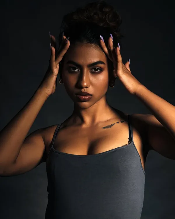 A powerful close-up portrait using dramatic lighting to sculpt the model's features. The intensity in her eyes is the focal point of this shot.