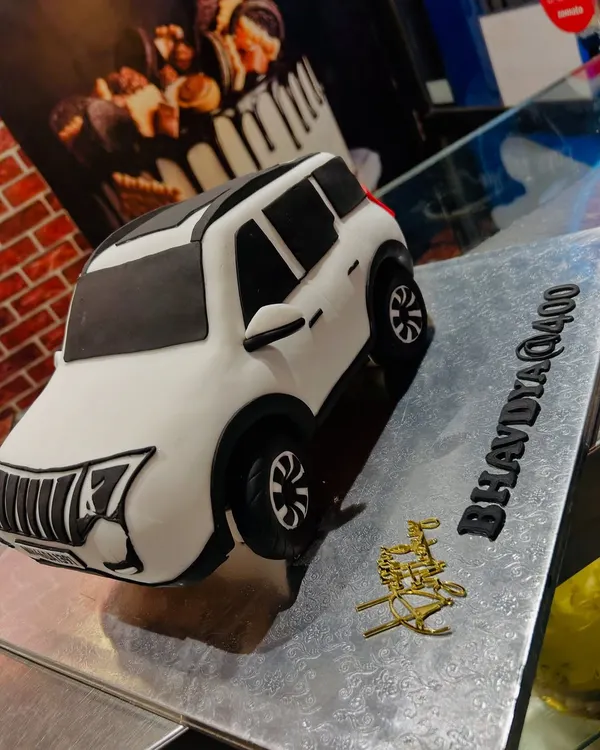A fully edible, hand-sculpted 3D cake of a white Mahindra XUV400. I recreated every detail, from the grille to the license plate, for a true car lover.