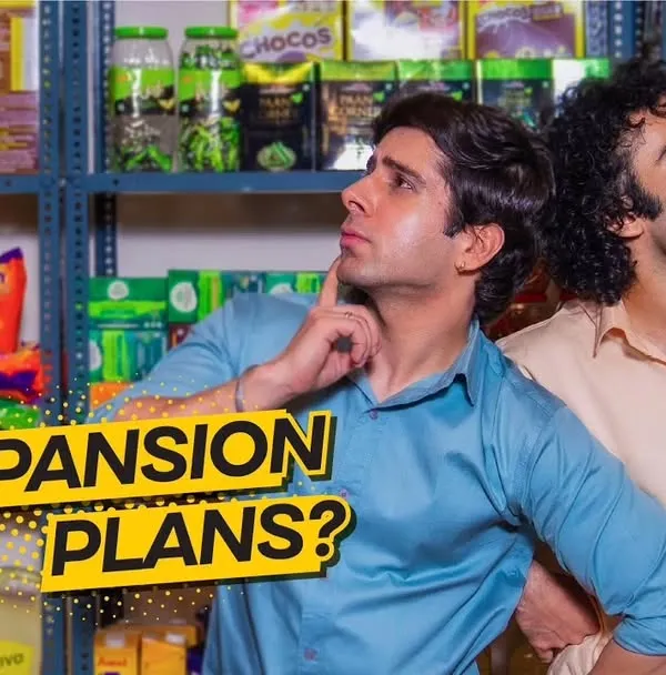 A promotional still from a business loan ad series for Shriram Finance, featured during the Cricket World Cup. This shot captures a moment of consideration between two business partners, designed for a high-visibility ad campaign.