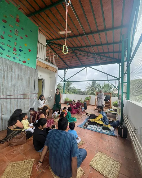 A wide view of our rooftop space during a community gathering. We use natural mats and have plenty of open floor for activities, all under a covered roof that lets in the light and air.