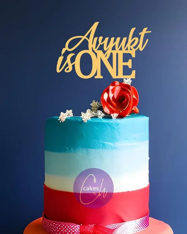 This colorful, multi-layered cake for Avyukt's first birthday is finished with a simple and elegant gold acrylic topper. The clean font is versatile and works well with any cake design.