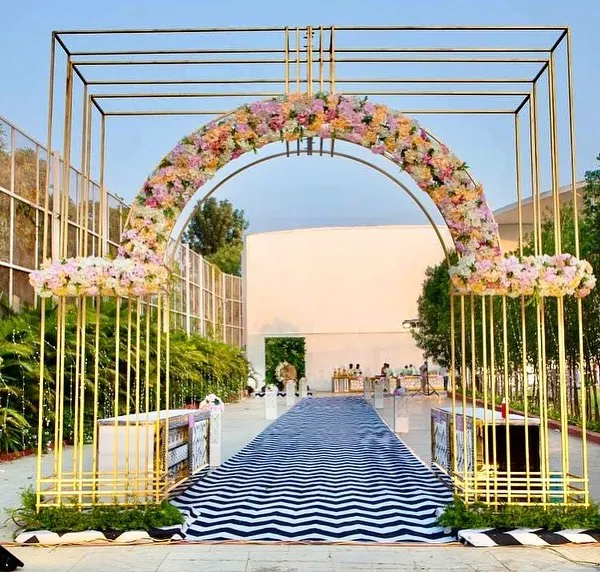 We love making a grand entrance. For this 60th birthday, we fabricated this stunning golden geometric archway, decorated with a lush floral arrangement, to welcome guests over a custom black and white chevron-patterned walkway.