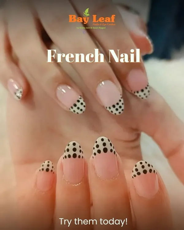 A playful and chic twist on a classic. These almond-shaped nails feature a modern French manicure with a fun black polka dot pattern on the tips for a unique style statement.