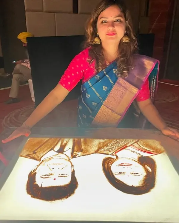 A happy moment captured with my finished sand art portrait. Creating these personalized pieces for celebrations is always a heartwarming experience.