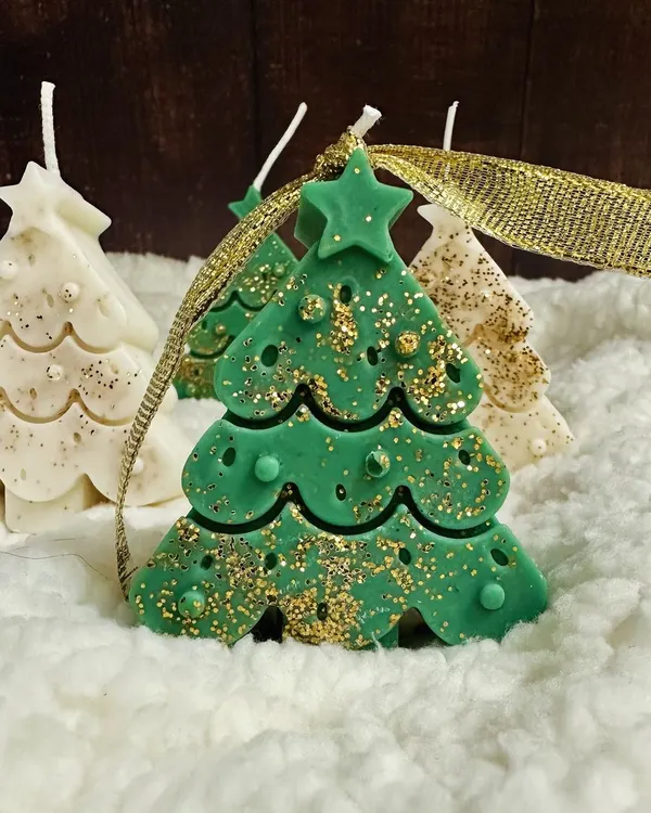 My green Christmas tree soy candle, sparkling with gold glitter. It's a perfect little piece to add a festive delight to your holiday decor.
