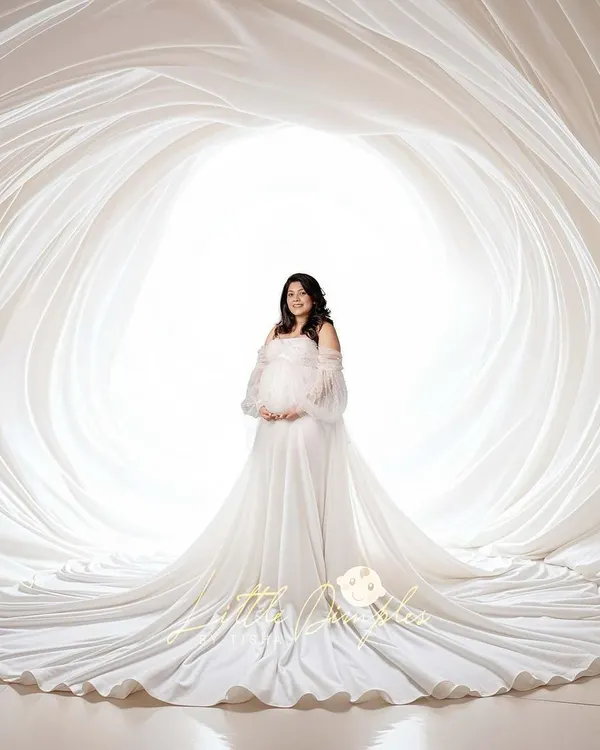 An all-white studio session creates such a heavenly and pure look. Here, we used layers of flowing white fabric to create a stunning cocoon effect for this diva mom-to-be.