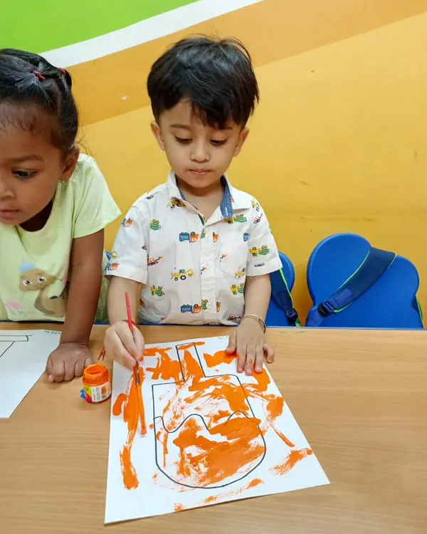 Life is a big canvas! A young artist is completely absorbed in painting the letter 'U', exploring colors and shapes with focus and creativity.