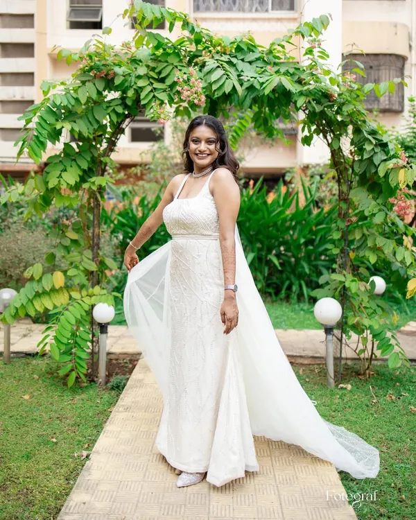 A vision of elegance in her white wedding gown. This bride is ready to walk down the aisle with a timeless look featuring cool purple tones, soft glam makeup, and romantic loose waves.