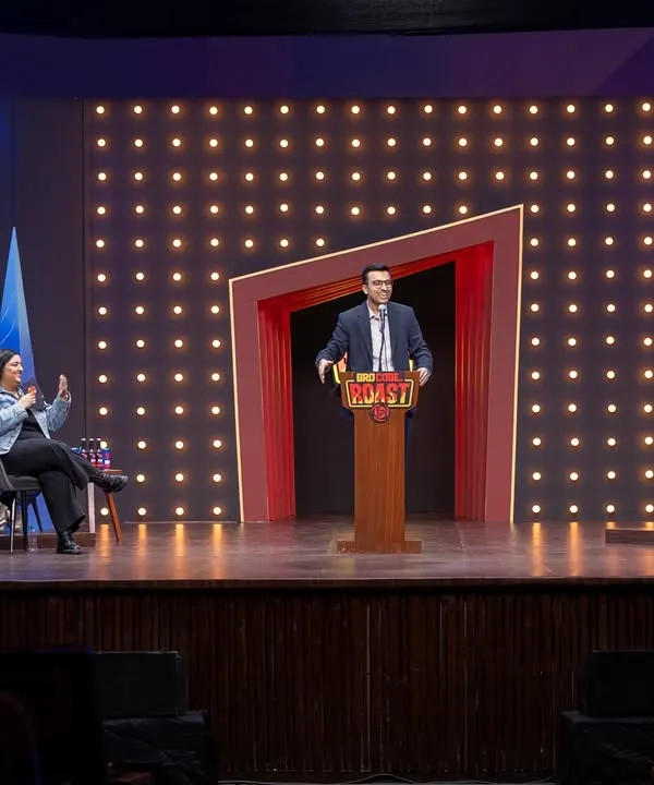 A wide shot of the 'Bro Code Roast' stage, capturing the host, the panel, and the audience. This gives a complete sense of the show's atmosphere and production value.