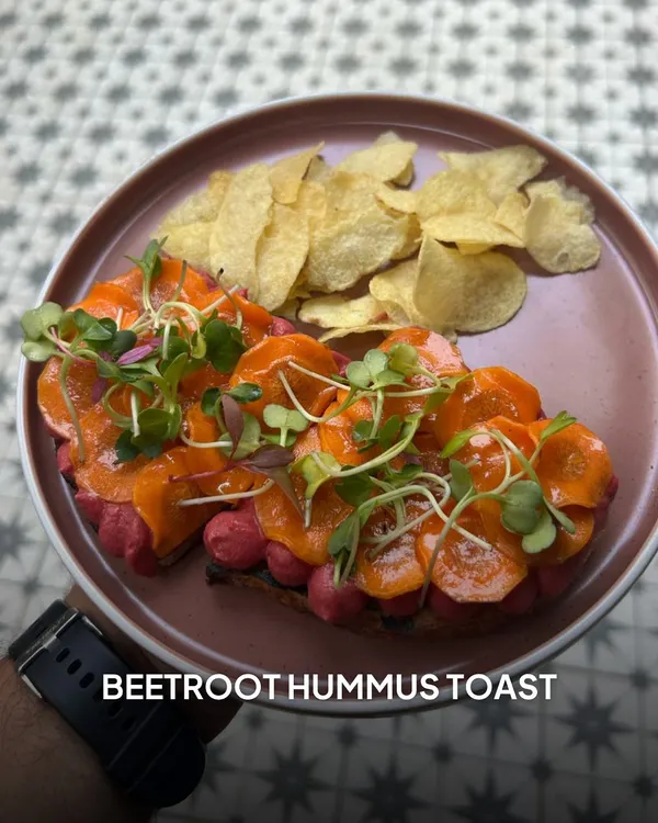 My Beetroot Hummus Toast is a feast for the eyes and the palate. It features creamy, house-made hummus topped with thinly sliced carrots and fresh microgreens on toasted bread.